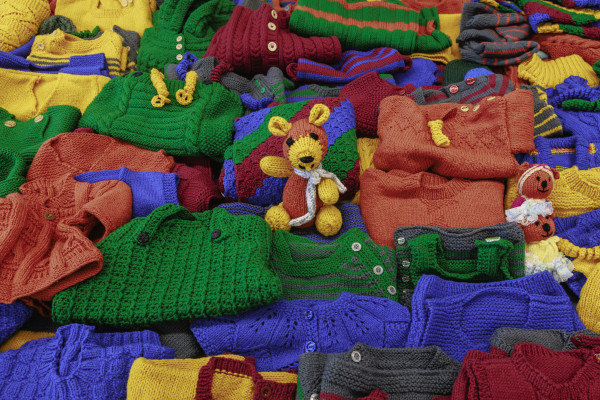 Knitted items made by Knit 'n' Yarn groups for the Knitted Communities Together project, including eanies, jerseys and teddies.